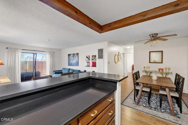 a dining hall with stainless steel appliances granite countertop a barbecue grill a dining table and chairs with wooden floor