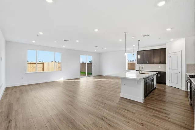 an open kitchen with a sink and a stove top oven