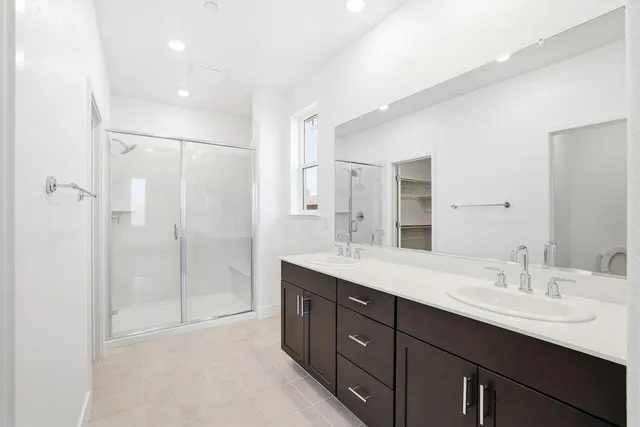 a bathroom with a double vanity sink mirror double and shower