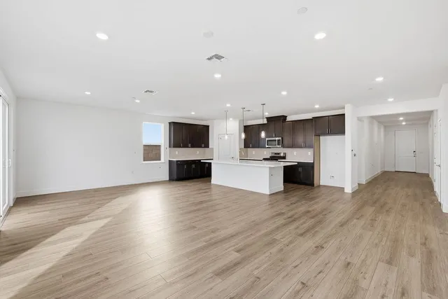 a view of kitchen with microwave a stove and wooden floor