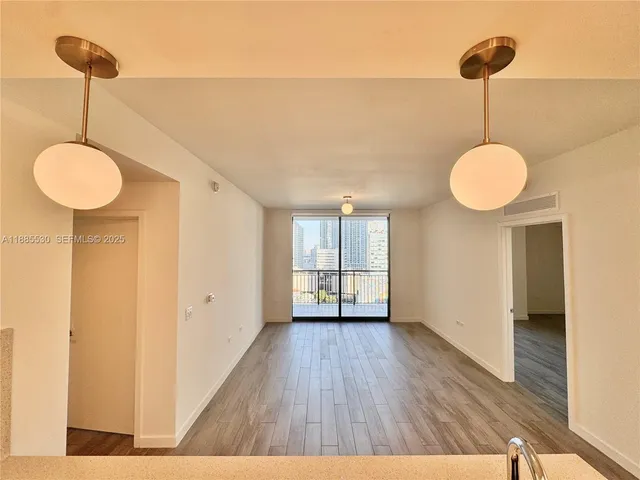 a view of an empty room with a chandelier fan