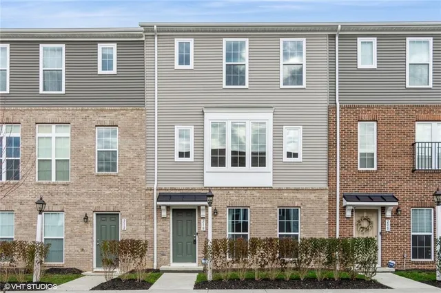 a front view of a building with a garden and plants