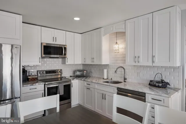 a kitchen with appliances a sink and cabinets