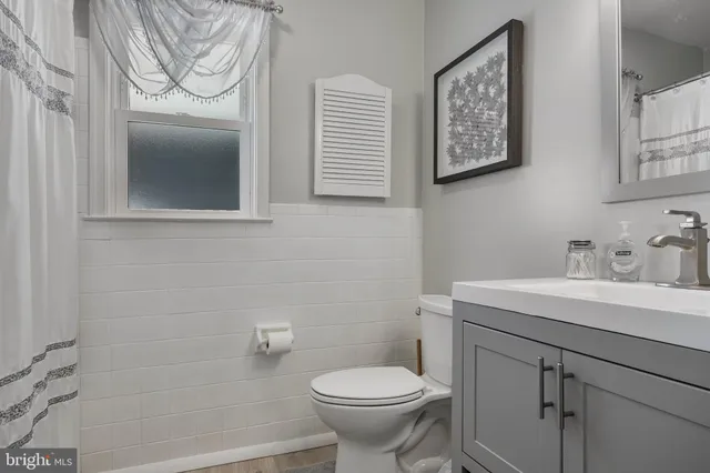 a bathroom with a sink toilet and a mirror
