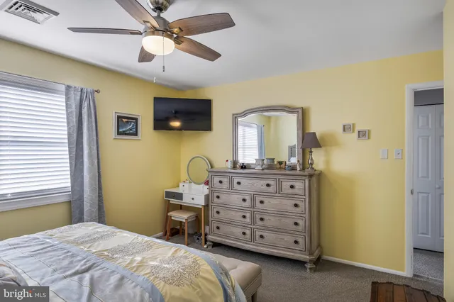 a bedroom with a bed a dresser and a flat screen tv