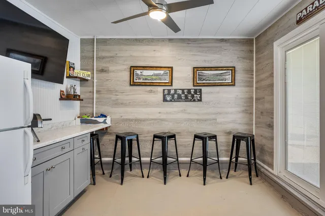 a dining hall with stainless steel appliances granite countertop a sink and a refrigerator