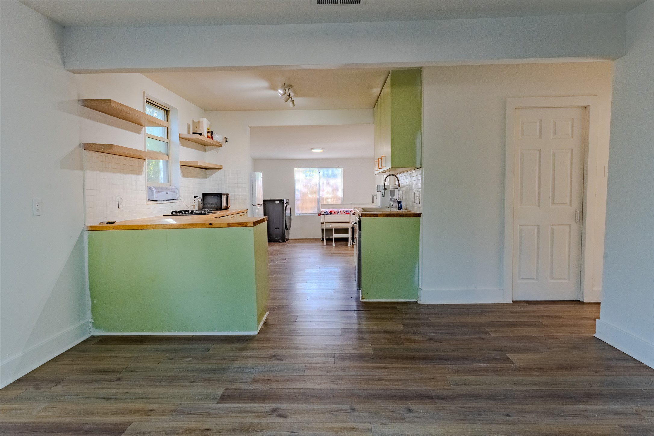 1120 Mark Street Austin, TX 78721 - Photo 6 of 22 Warm wood-look flooring anchors this versatile open layout connecting the kitchen and living areas.