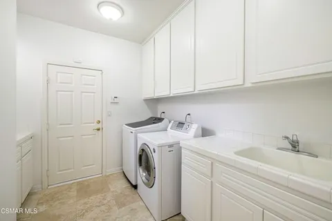 a utility room with sink dryer and washer