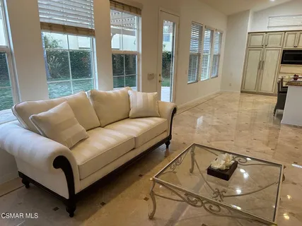 a living room with furniture and a floor to ceiling window