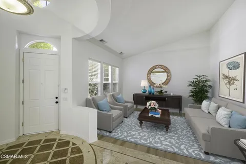 a living room with furniture a rug and a window