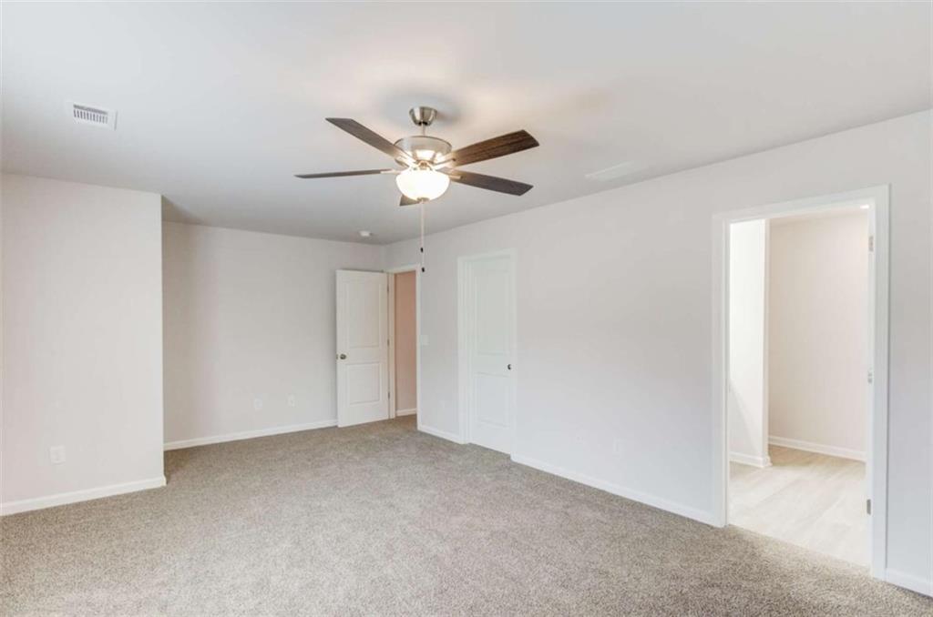 6342 Pine Ridge Point Lula, GA 30554 - Photo 17 of 27 an empty room with a ceiling fan and a window