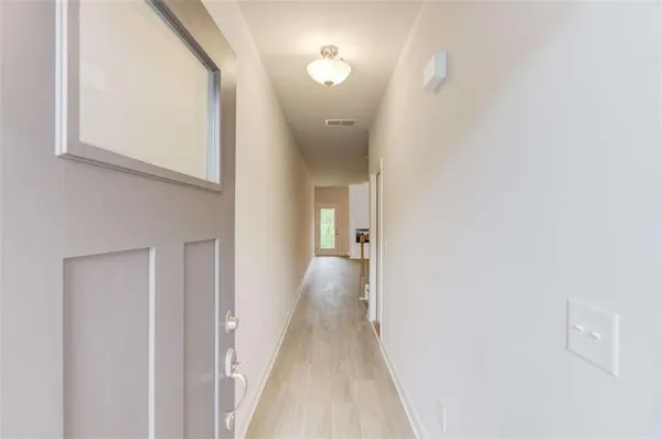 a view of staircase with lots of frames on wall and a window