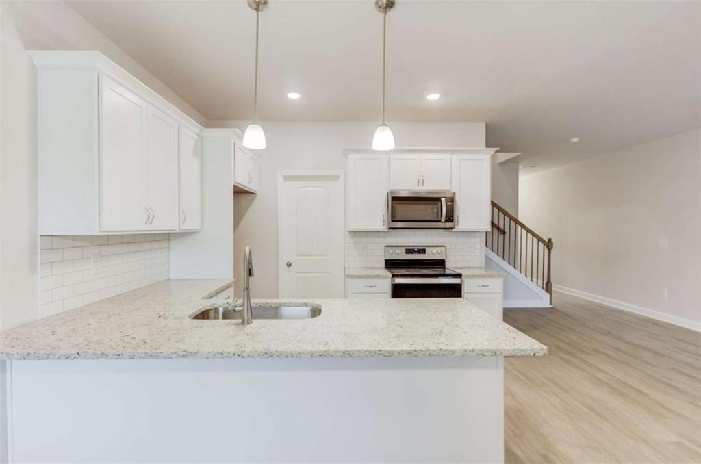 6342 Pine Ridge Point Lula, GA 30554 - Photo 10 of 27 a kitchen with stainless steel appliances granite countertop a sink a stove and a granite counter top