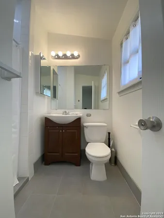 a bathroom with a toilet sink and mirror