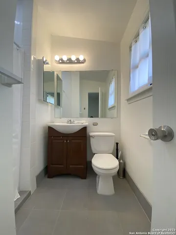 a bathroom with a toilet sink and mirror