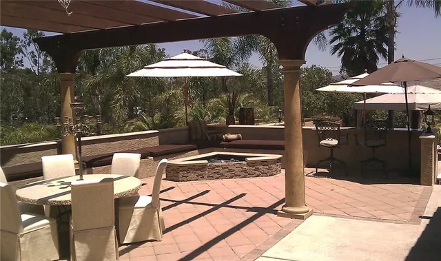 a kitchen with stainless steel appliances granite countertop a stove top oven a sink a dining table and chairs with white cabinets