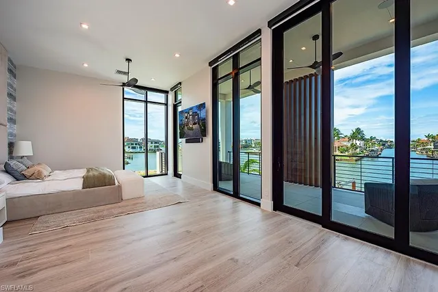 a large bedroom with bed and glass door