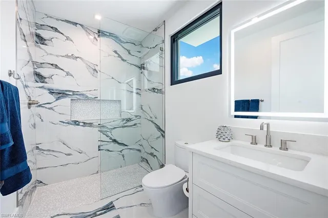 a bathroom with a sink toilet and mirror