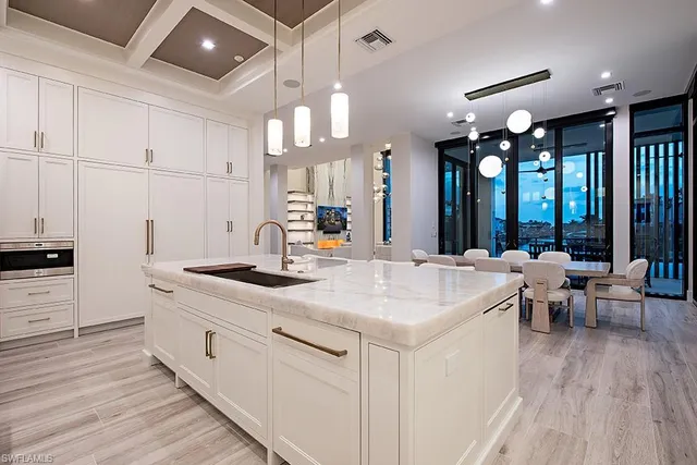 a kitchen with sink stove and white cabinets with wooden floor