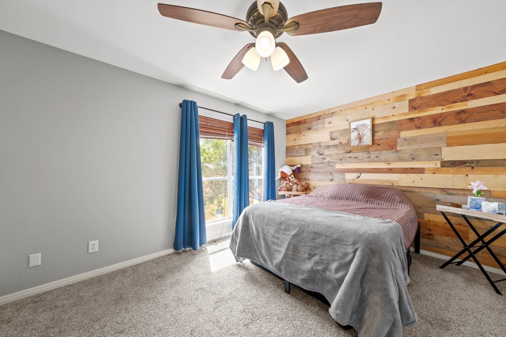 1100 Martindale Falls Road Martindale, TX 78655 - Photo 12 of 31 Bedroom featuring wooden walls, carpet flooring, and ceiling fan