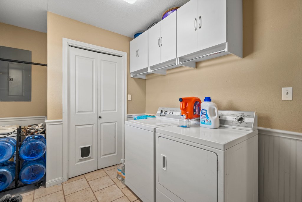 1100 Martindale Falls Road Martindale, TX 78655 - Photo 16 of 31 Laundry room featuring a wainscoted wall, electric panel, independent washer and dryer, cabinet space, and a decorative wall