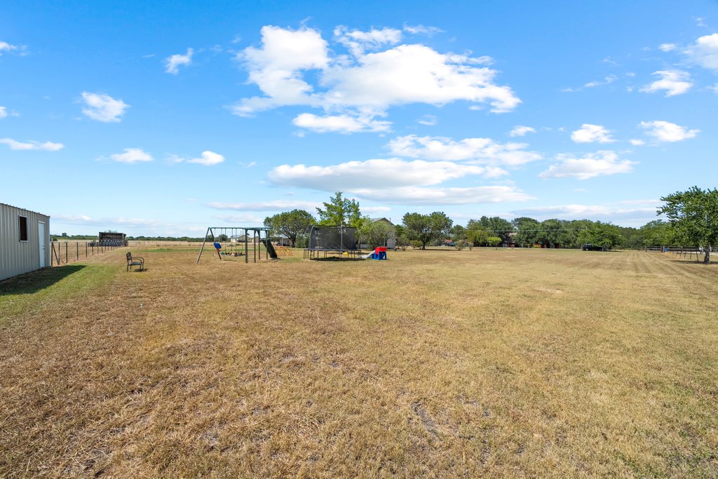 1100 Martindale Falls Road Martindale, TX 78655 - Photo 20 of 31 View of yard featuring a trampoline, a playground, and a view of countryside