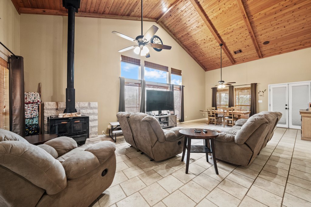 1100 Martindale Falls Road Martindale, TX 78655 - Photo 3 of 31 Living area featuring a wood stove, a wood ceiling with exposed beams, high vaulted ceiling, and french doors