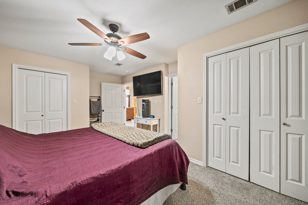 1100 Martindale Falls Road Martindale, TX 78655 - Photo 8 of 31 Carpeted bedroom featuring multiple closets and ceiling fan