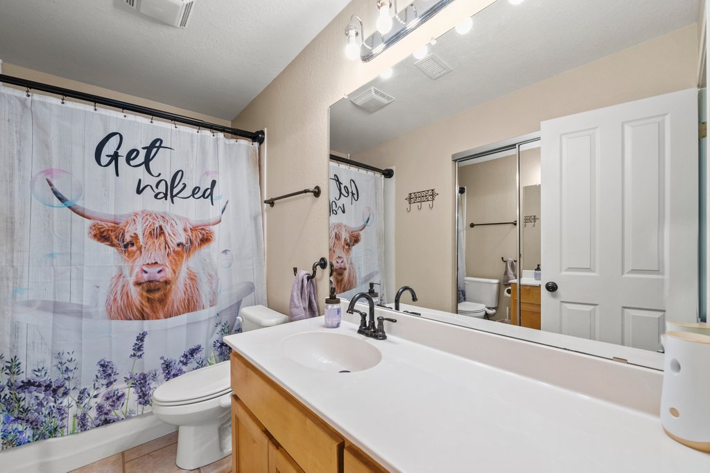 1100 Martindale Falls Road Martindale, TX 78655 - Photo 9 of 31 Full bathroom featuring vanity, light tile patterned floors, and shower / bathtub combination with curtain