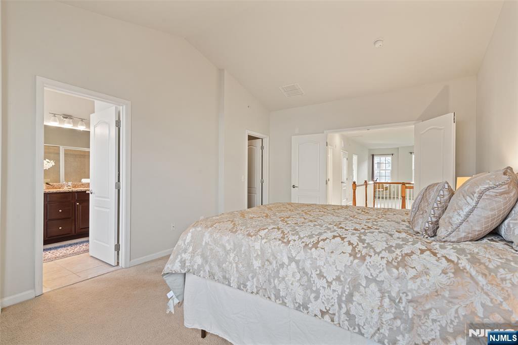 43 Wesmont Drive, Unit 1712 Wood-Ridge, NJ 07075 - Photo 12 of 35 a bedroom with a bed and a large mirror