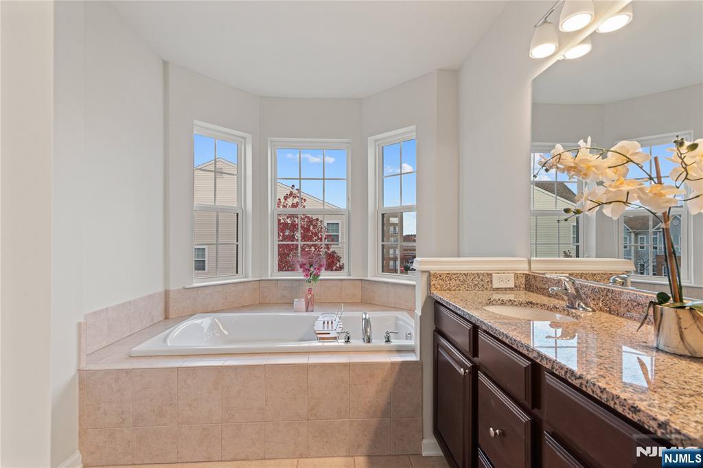 43 Wesmont Drive, Unit 1712 Wood-Ridge, NJ 07075 - Photo 14 of 35 a bath tub sitting next to a bathroom sink