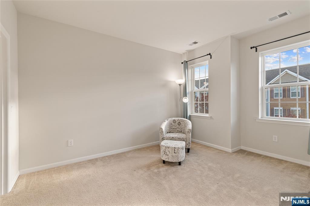 43 Wesmont Drive, Unit 1712 Wood-Ridge, NJ 07075 - Photo 19 of 35 a room with a chair and a window