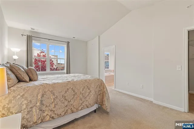 a bedroom with a large bed and a painting on the wall