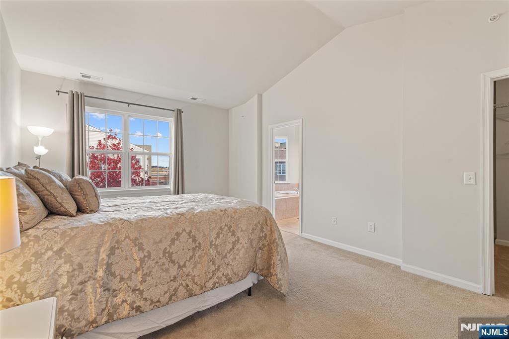 43 Wesmont Drive, Unit 1712 Wood-Ridge, NJ 07075 - Photo 21 of 35 a bedroom with a large bed and a painting on the wall