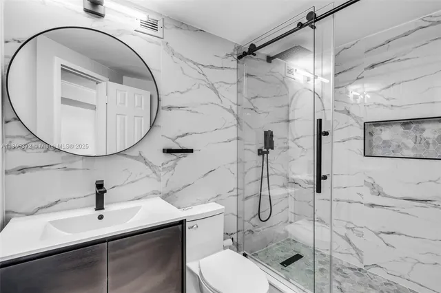 a bathroom with a sink toilet and shower