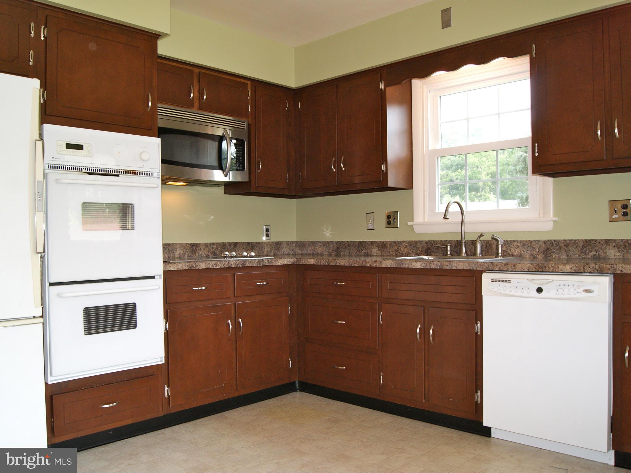 9221 Cornflower Road Baltimore, MD 21236 - Photo 11 of 25 a kitchen with granite countertop white cabinets and white appliances
