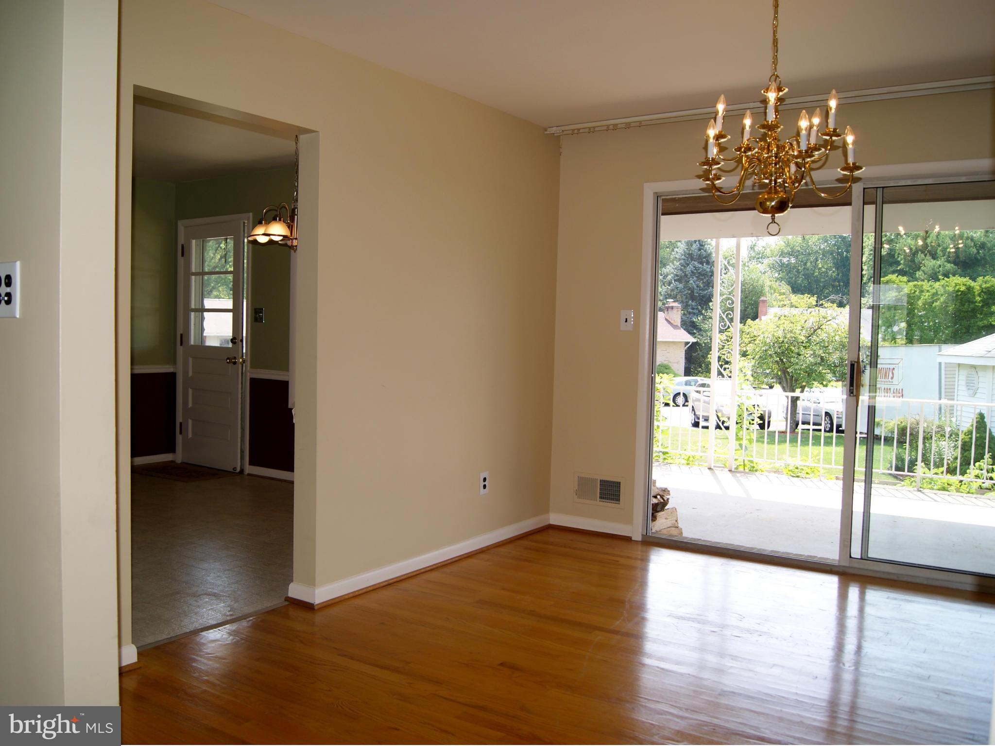 9221 Cornflower Road Baltimore, MD 21236 - Photo 14 of 25 a view of a big room with wooden floor a chandelier and living room