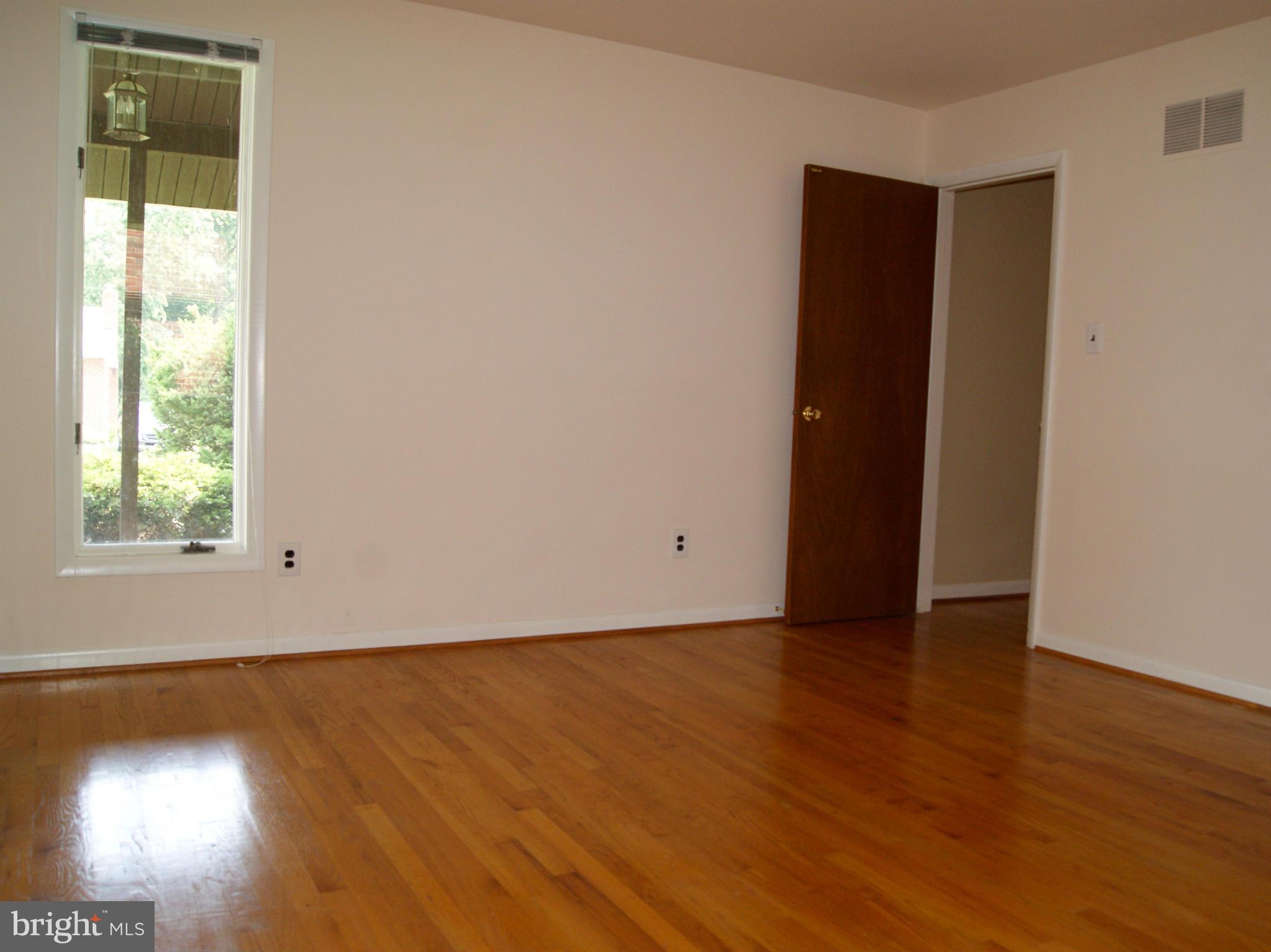 9221 Cornflower Road Baltimore, MD 21236 - Photo 16 of 25 an empty room with wooden floor and windows