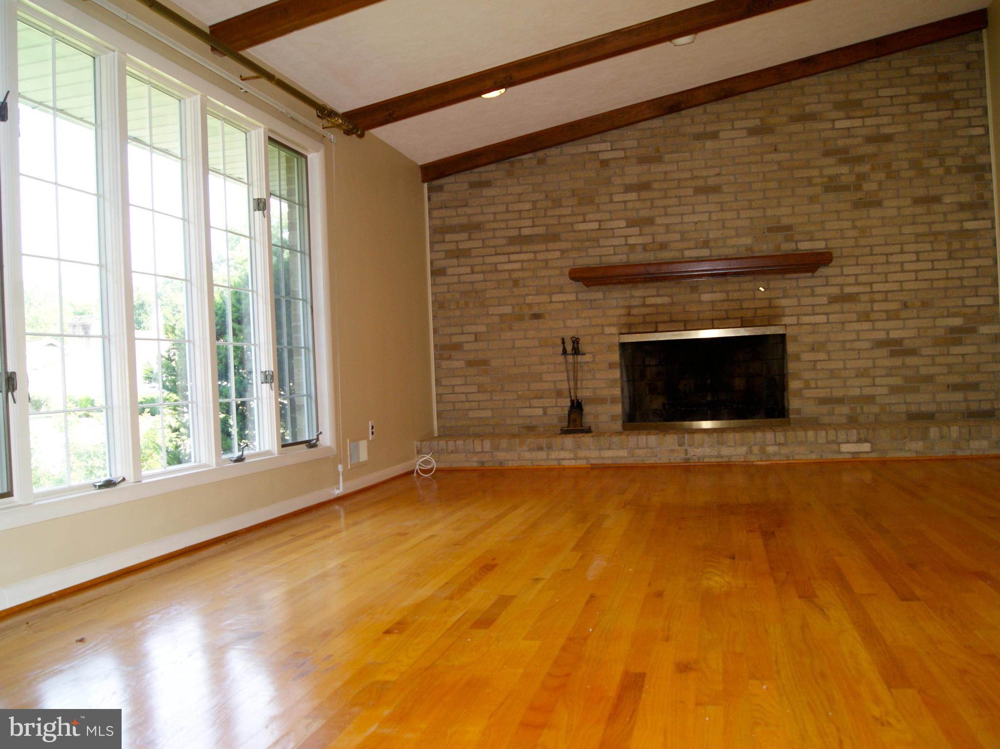 9221 Cornflower Road Baltimore, MD 21236 - Photo 9 of 25 a view of an empty room with a fireplace and a window