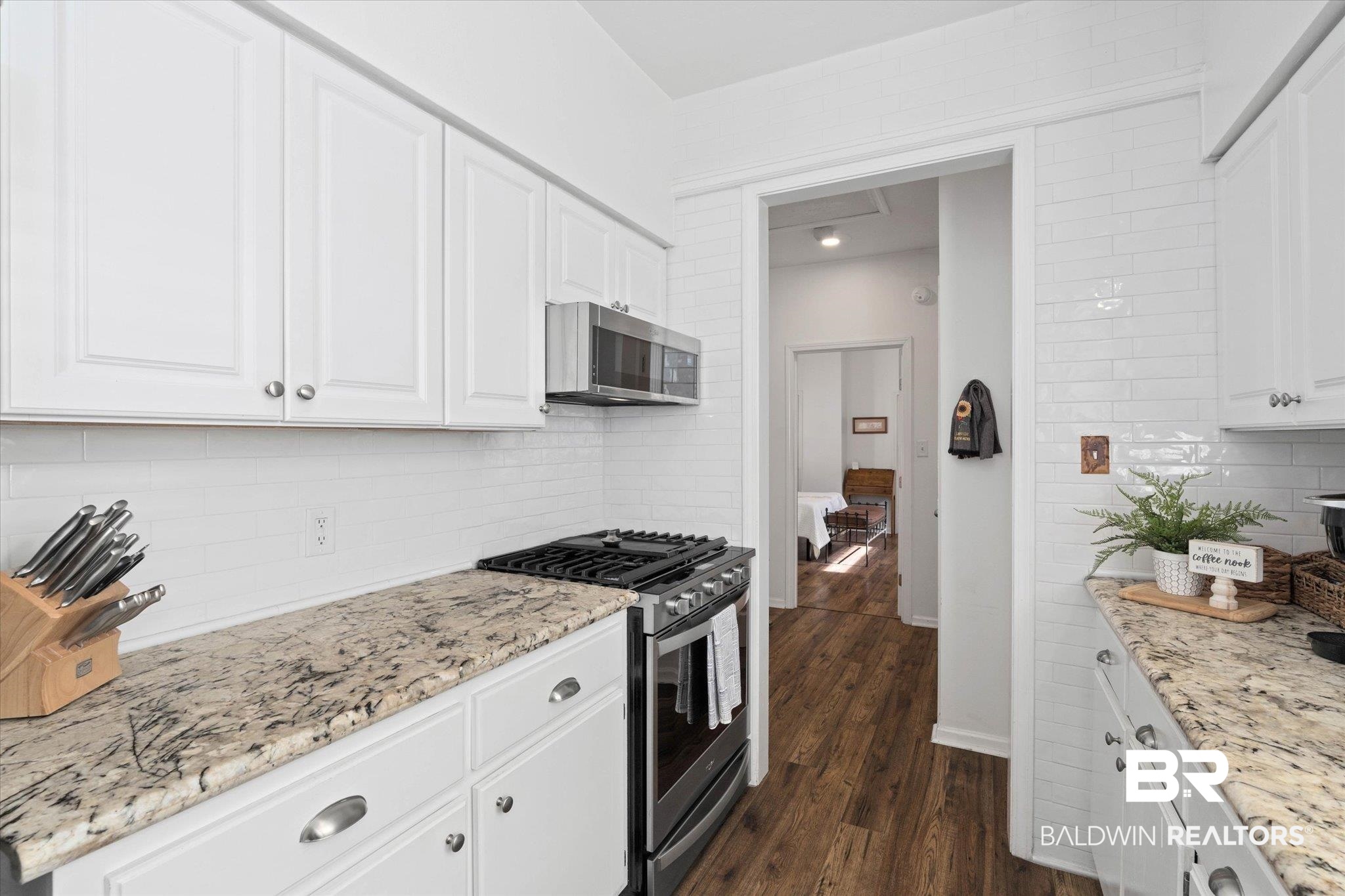 1910 Hunter Avenue Mobile, AL 36606 - Photo 8 of 21 Kitchen with stainless steel appliances, tasteful backsplash, white cabinets, and dark wood-type flooring