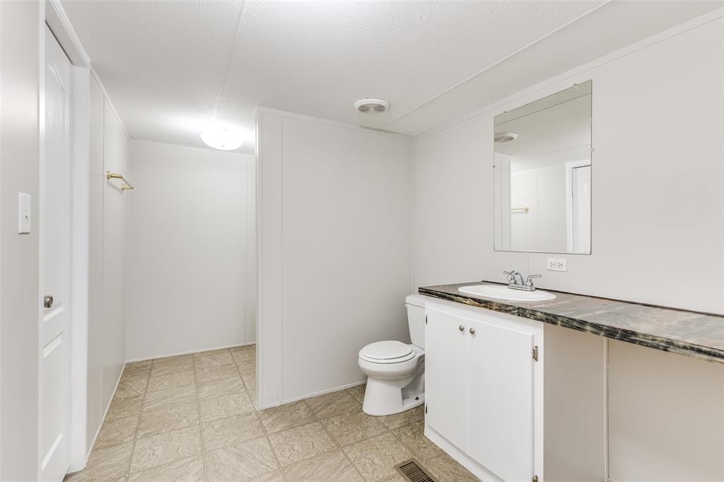 445 Arvel Circle Azle, TX 76020 - Photo 18 of 25 a bathroom with a granite countertop sink a toilet and a mirror