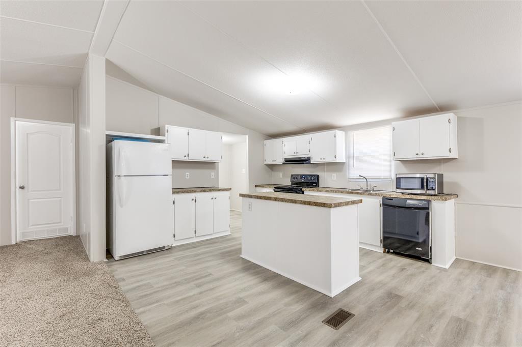 445 Arvel Circle Azle, TX 76020 - Photo 7 of 25 a kitchen with white cabinets and white appliances