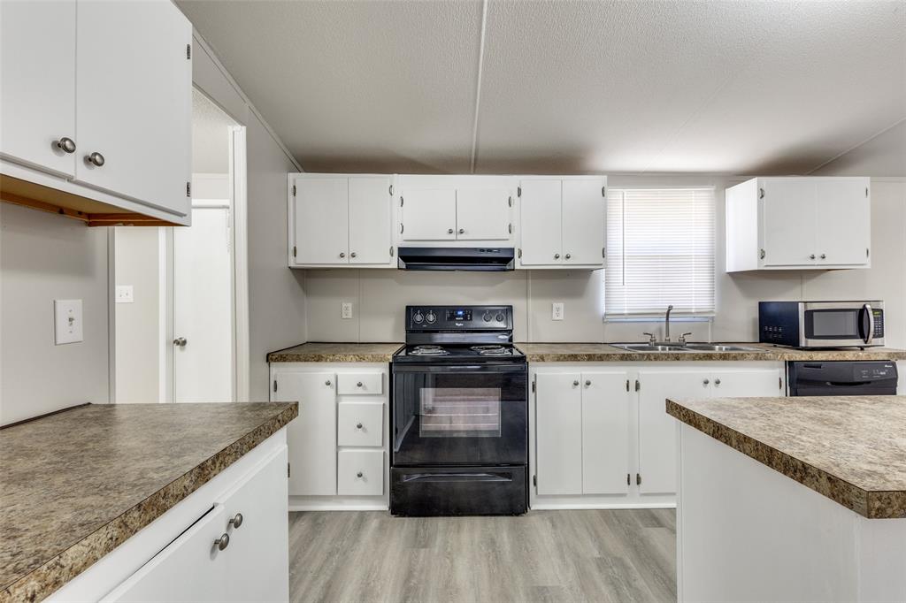 445 Arvel Circle Azle, TX 76020 - Photo 8 of 25 a kitchen with granite countertop a stove sink and cabinets