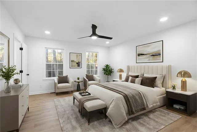 a bedroom with a large bed couch and windows