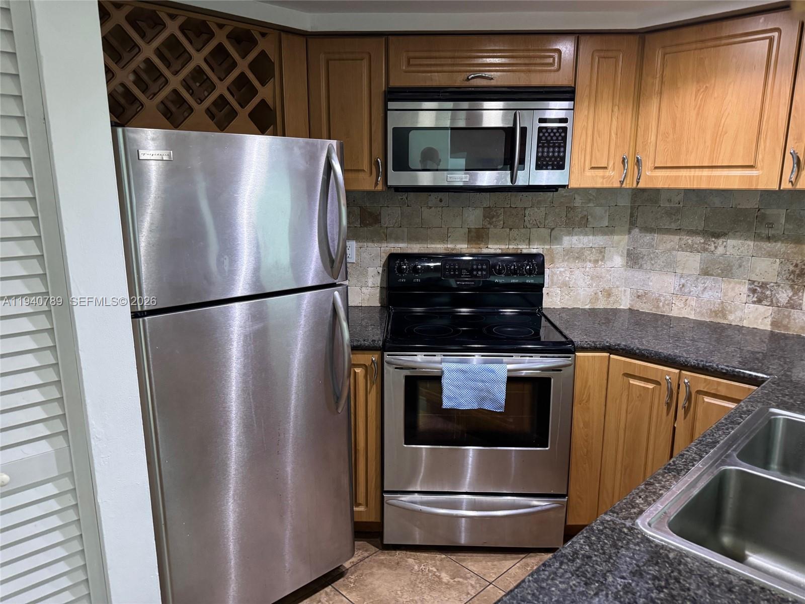 8335 Southwest 152nd Avenue, Unit B309 Miami, FL 33193 - Photo 12 of 26 a kitchen with metallic refrigerator and microwave