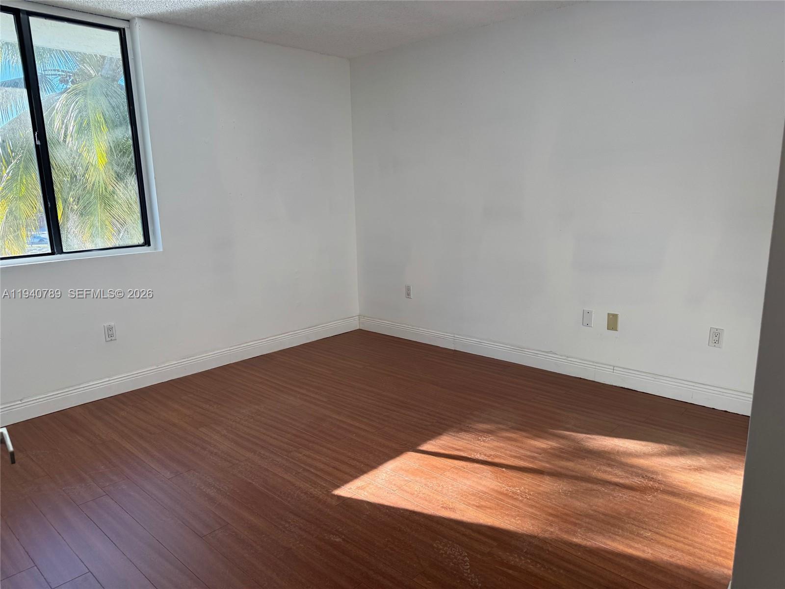 8335 Southwest 152nd Avenue, Unit B309 Miami, FL 33193 - Photo 16 of 26 a view of empty room with wooden floor and fan