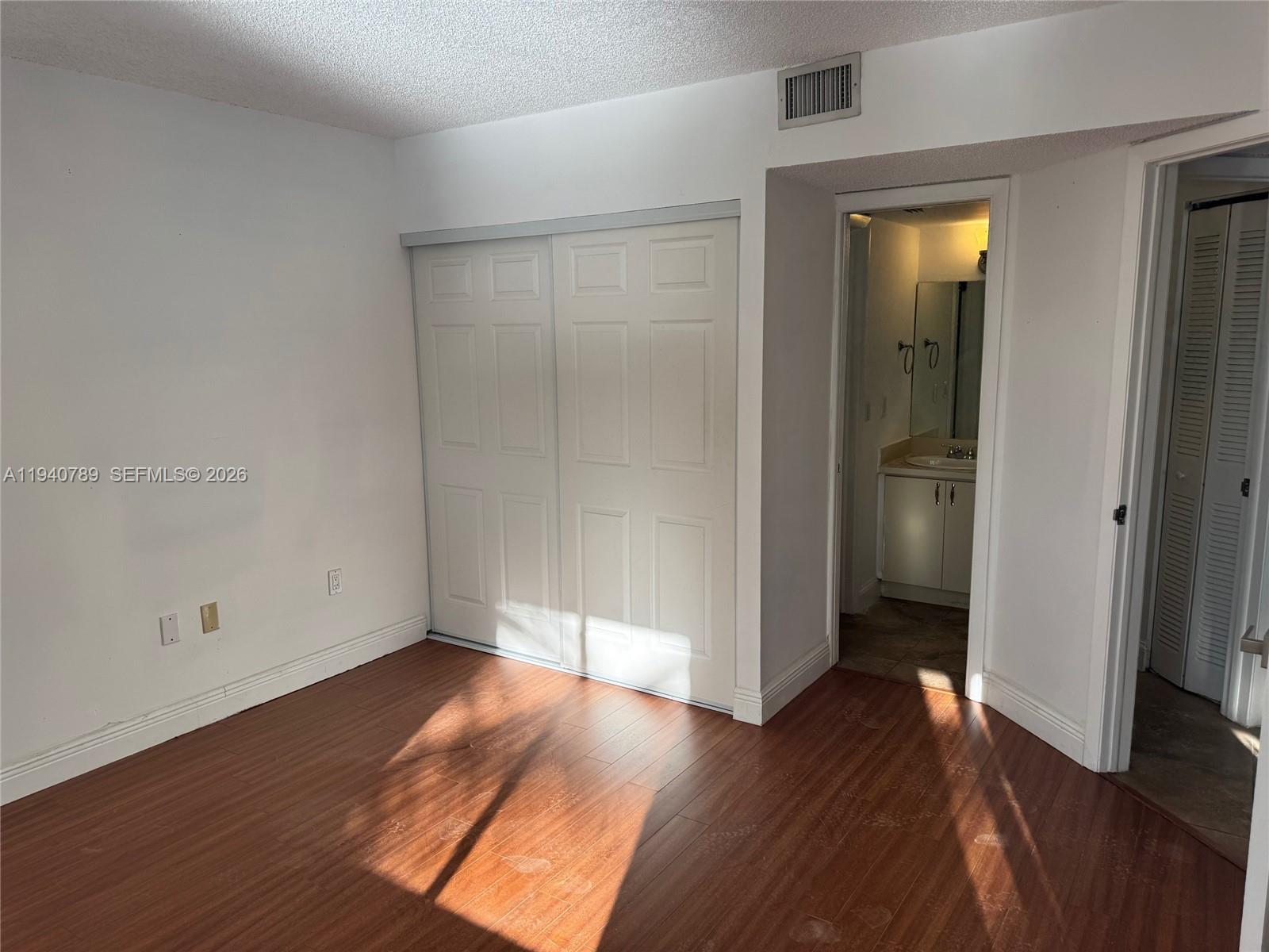 8335 Southwest 152nd Avenue, Unit B309 Miami, FL 33193 - Photo 18 of 26 an empty room with wooden floor and closet