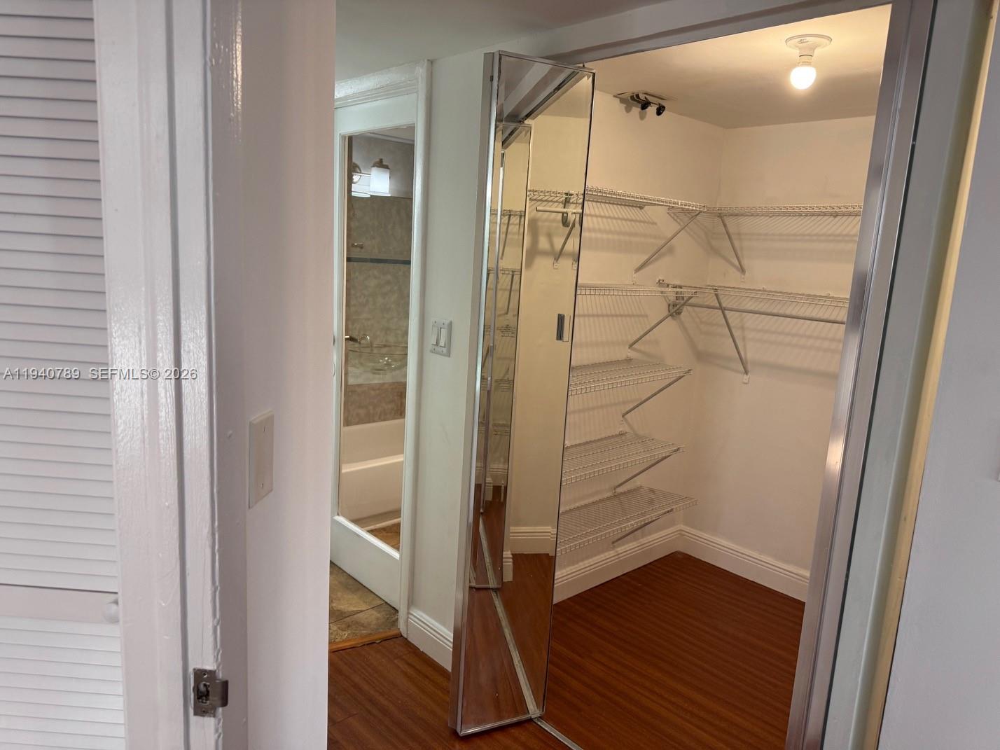 8335 Southwest 152nd Avenue, Unit B309 Miami, FL 33193 - Photo 20 of 26 a bathroom with a glass shower door and a mirror
