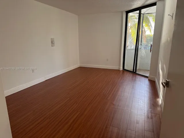 a view of a room with a floor to ceiling window and potted plants