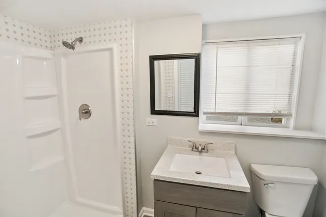 a bathroom with a sink a toilet and shower